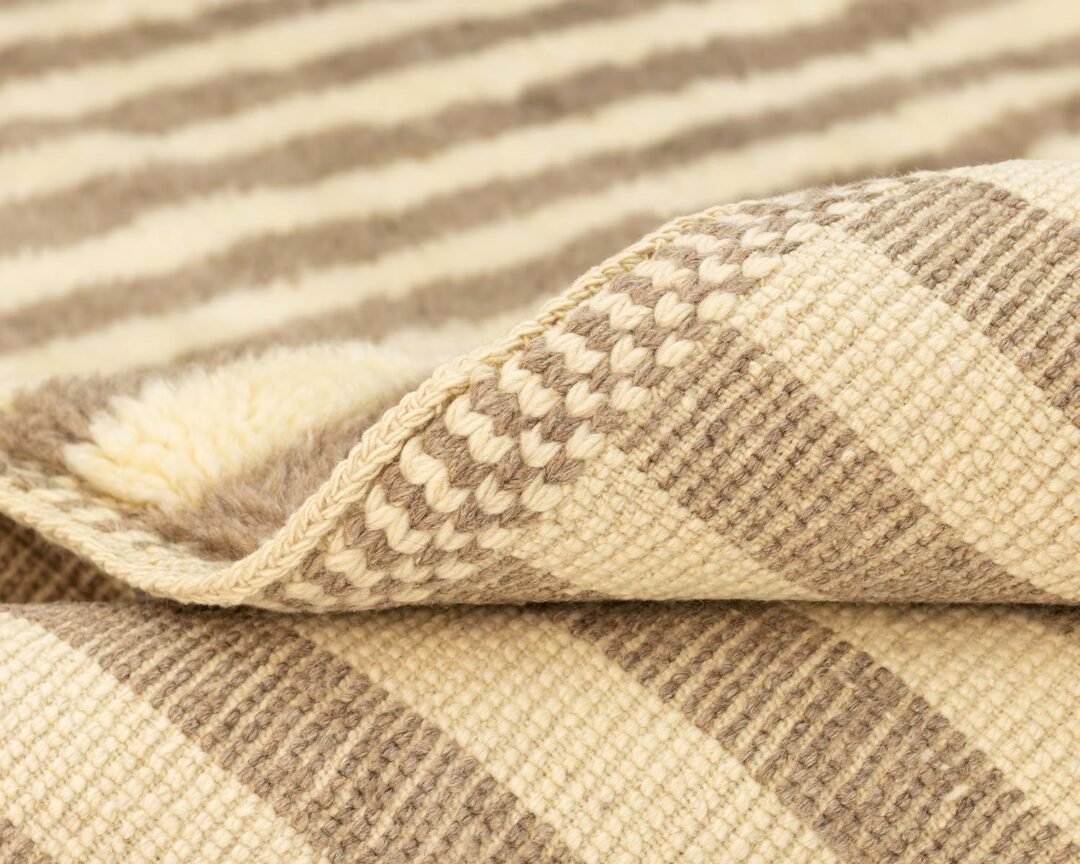 A close-up reveals the textured beauty of woven fabric, featuring cream and brown stripes that enhance its intricate pattern.