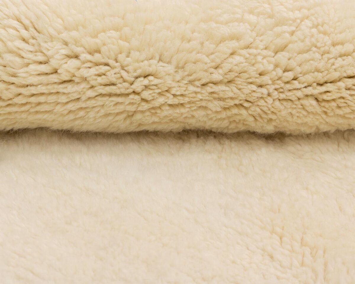 The close-up reveals a soft, creamy beige fleece texture, highlighting its fluffy, cloud-like plushness.