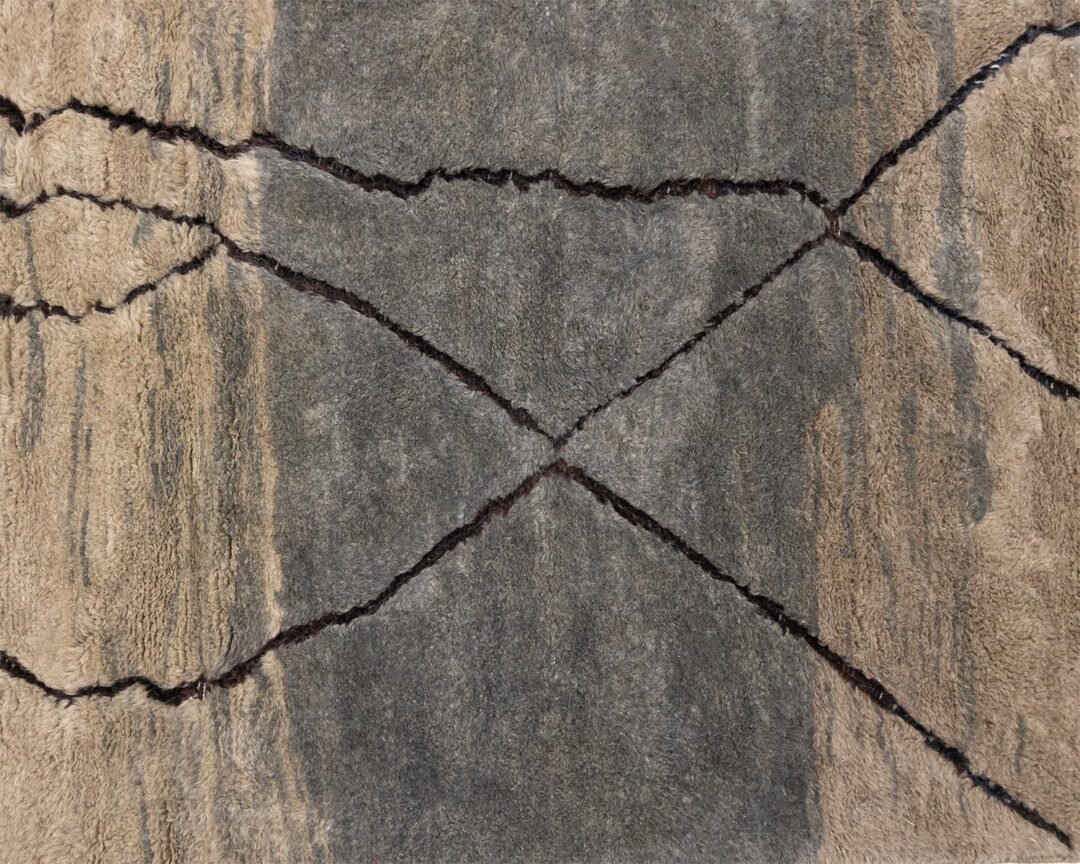 Aerial view of dry terrain with large, intersecting cracks forming abstract patterns across the landscape, reminiscent of the intricate designs found in authentic Moroccan rugs.