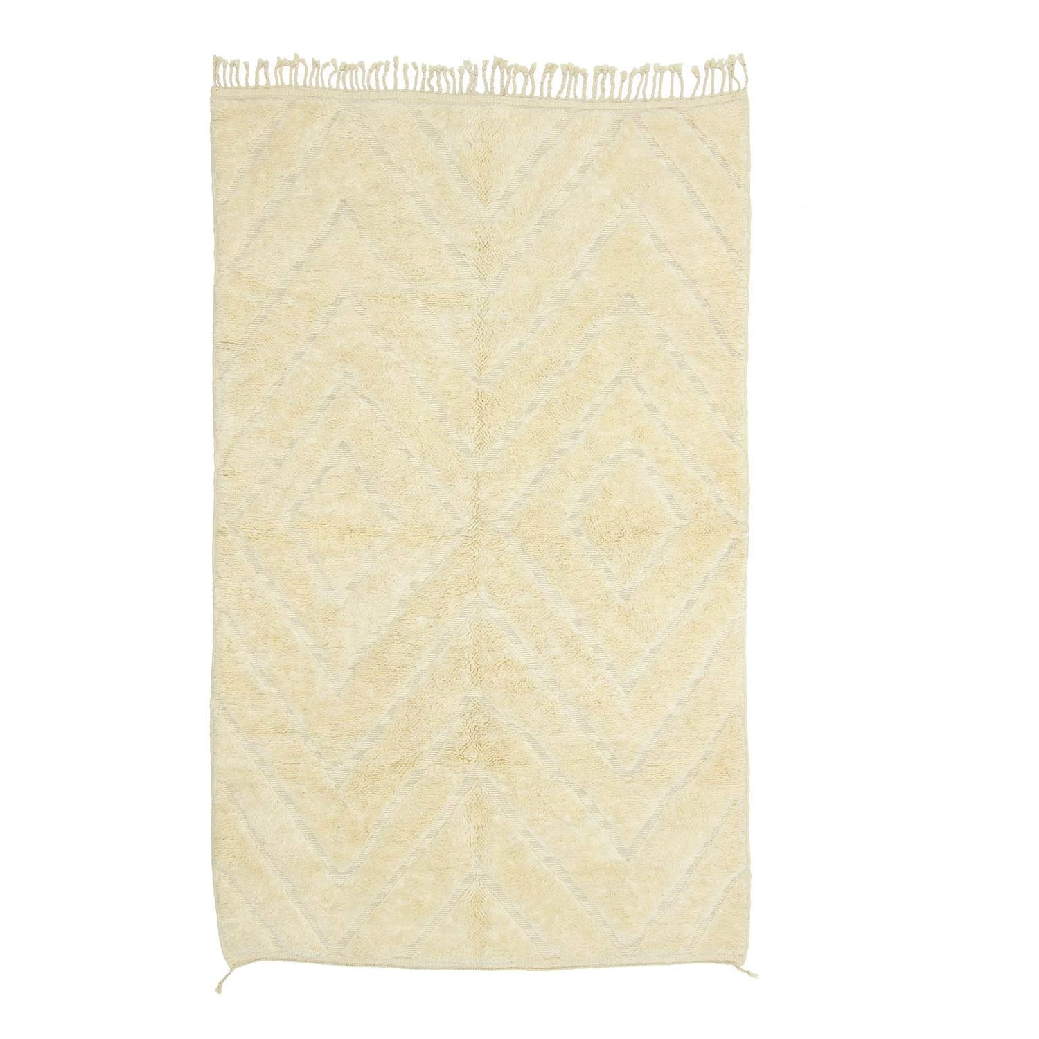 This hand-knotted beige rug features fringed edges and a subtle geometric diamond pattern, reminiscent of authentic Moroccan rugs.