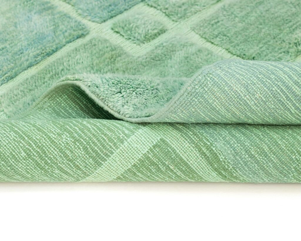 Close-up view of a folded green carpet with a diamond pattern.
