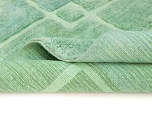 Close-up view of a folded green carpet with a diamond pattern.