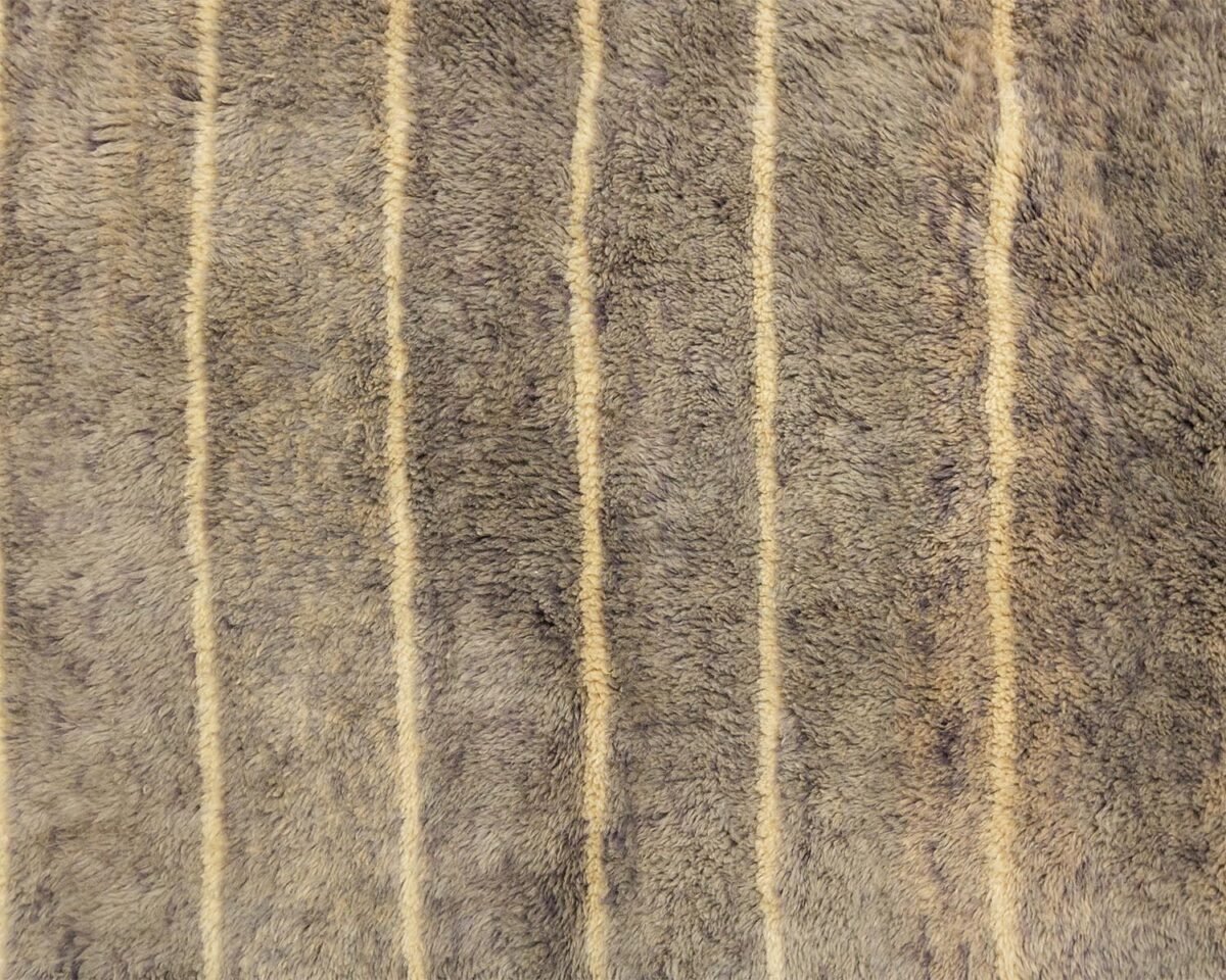 A close-up of a textured brown and beige fur surface, adorned with elegant vertical stripes.