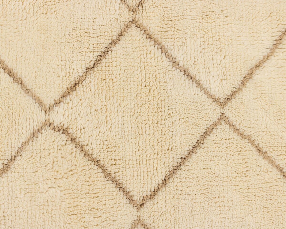 Close-up of a beige textured material featuring a diamond pattern created by intersecting dark lines. The intricate design adds an elegant touch to the fabric, making it suitable for various home decor applications.