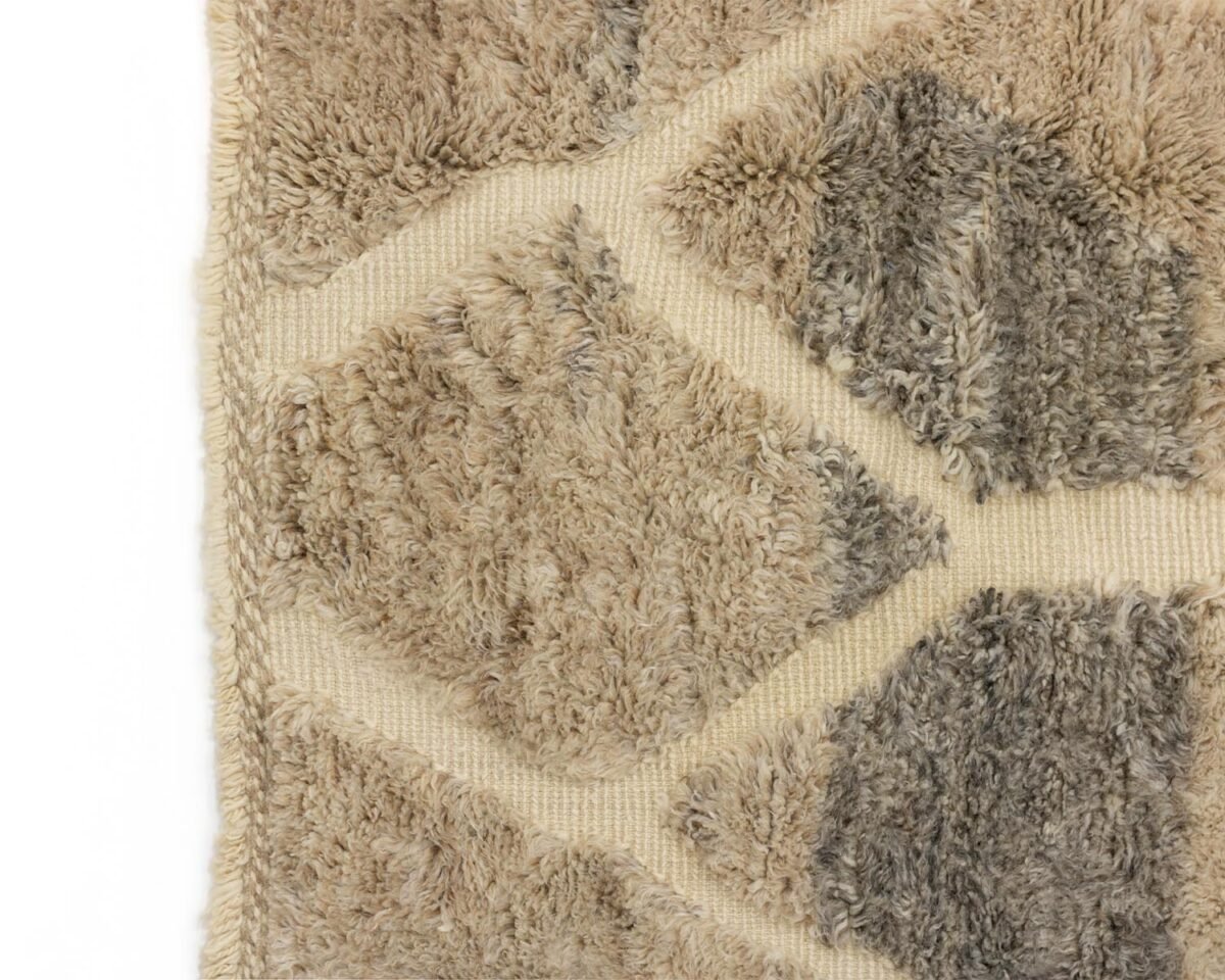 Close-up of a stylish beige and gray geometric-patterned rug boasting a plush, tufted surface.