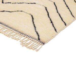 A chic cream-colored rug featuring diagonal black stripes and elegant fringe detailing.