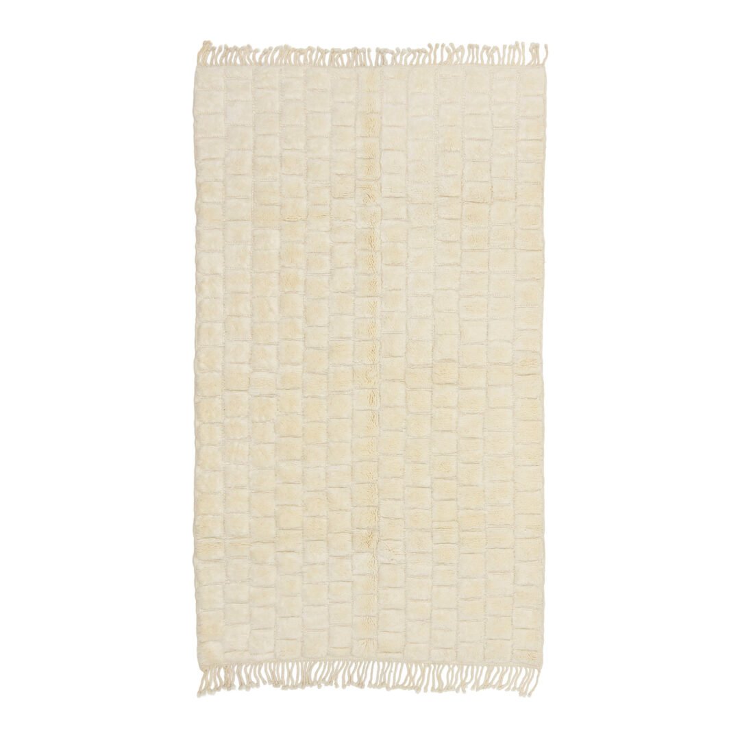 An artisanal beige rectangular rug with a grid pattern and fringed edges.