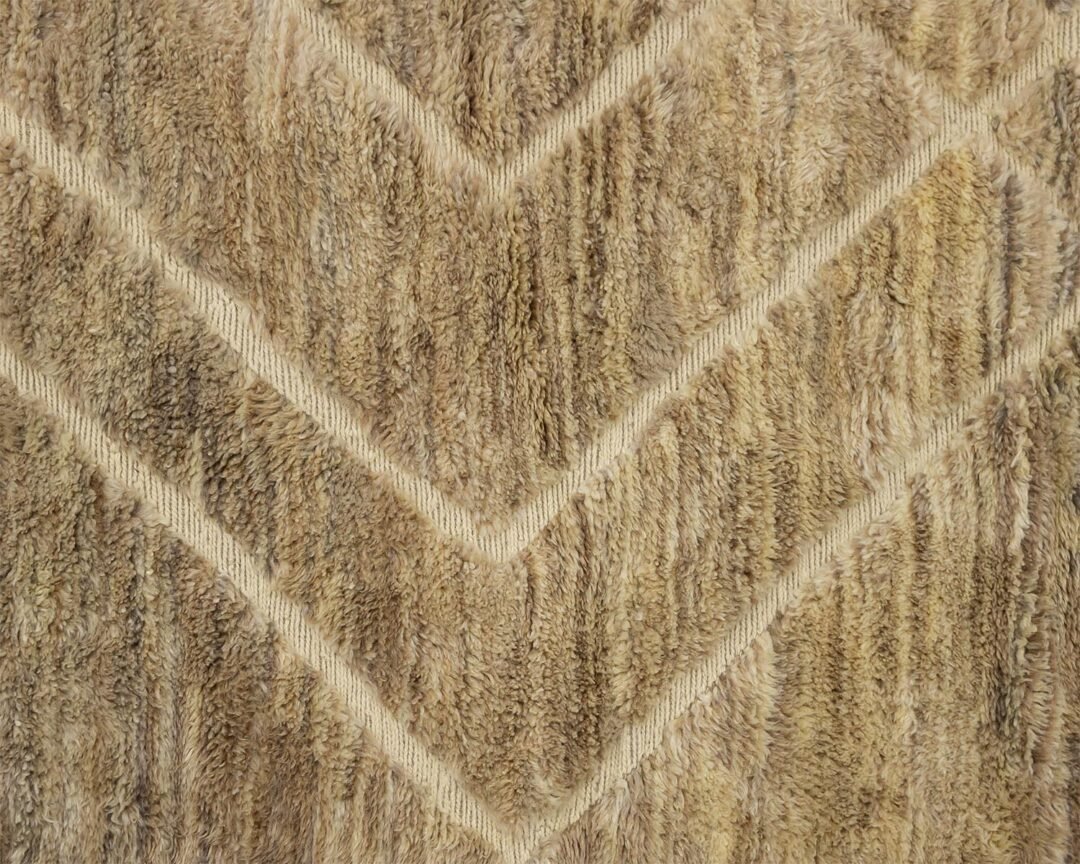 A close-up reveals a textured carpet featuring a chevron pattern with interwoven beige and brown tones.