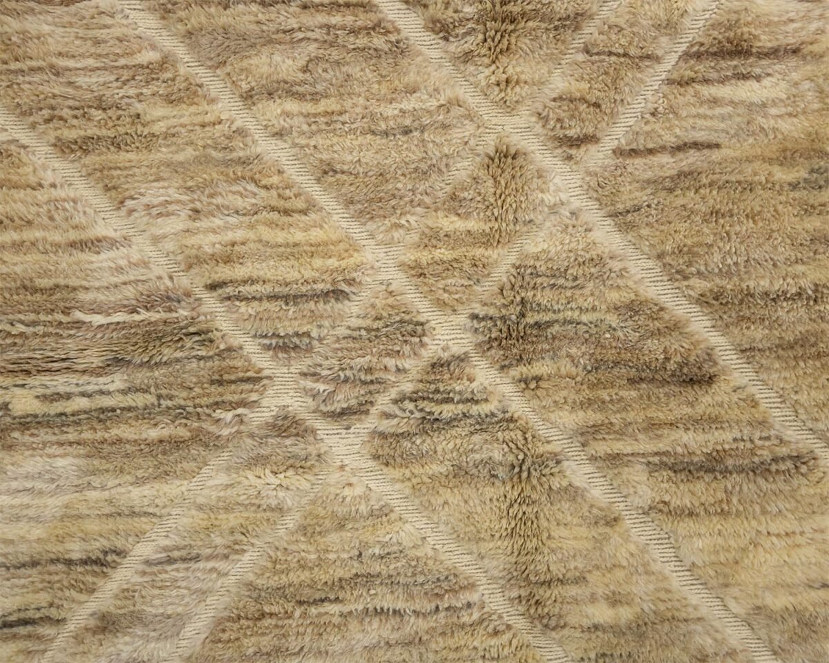 Close-up of a beige and brown textured shag rug featuring intersecting diagonal lines that form striking diamond patterns. The plush, inviting texture adds warmth and depth to any room, creating a cozy atmosphere.