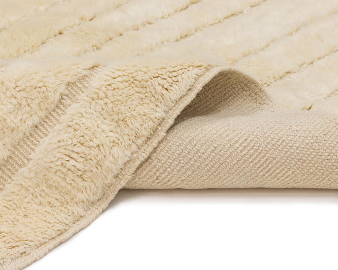 This cozy, beige fleece throw features a textured fabric on one side and a smooth, knitted surface on the other, partially folded to showcase both textures.