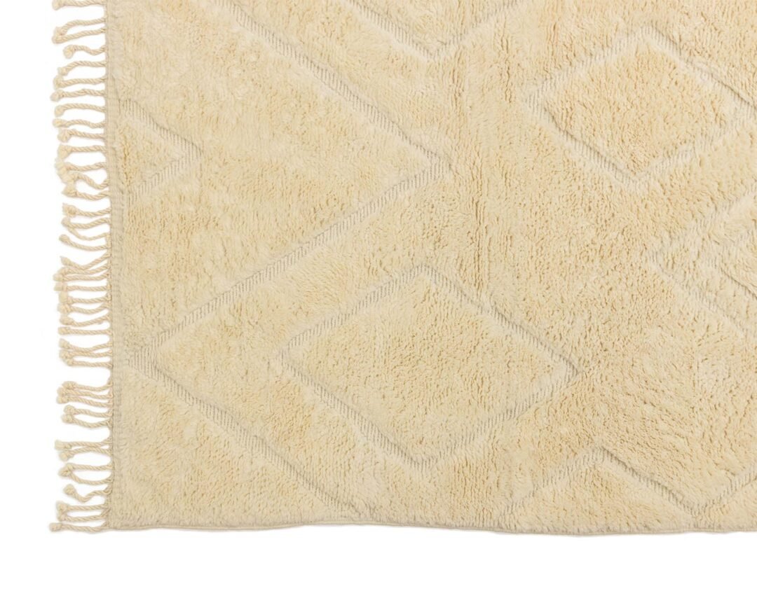 Experience the charm of an authentic Moroccan rug with this beige textured masterpiece. Featuring a hand-knotted diamond pattern and elegant fringe edges, it embodies artisanal craftsmanship at its finest.