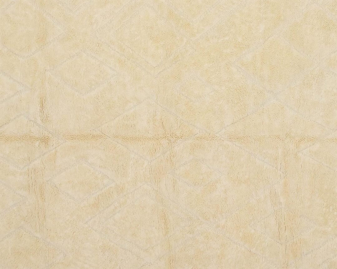 Close-up of an artisanal rug, showcasing a beige fabric with a subtle diamond pattern.