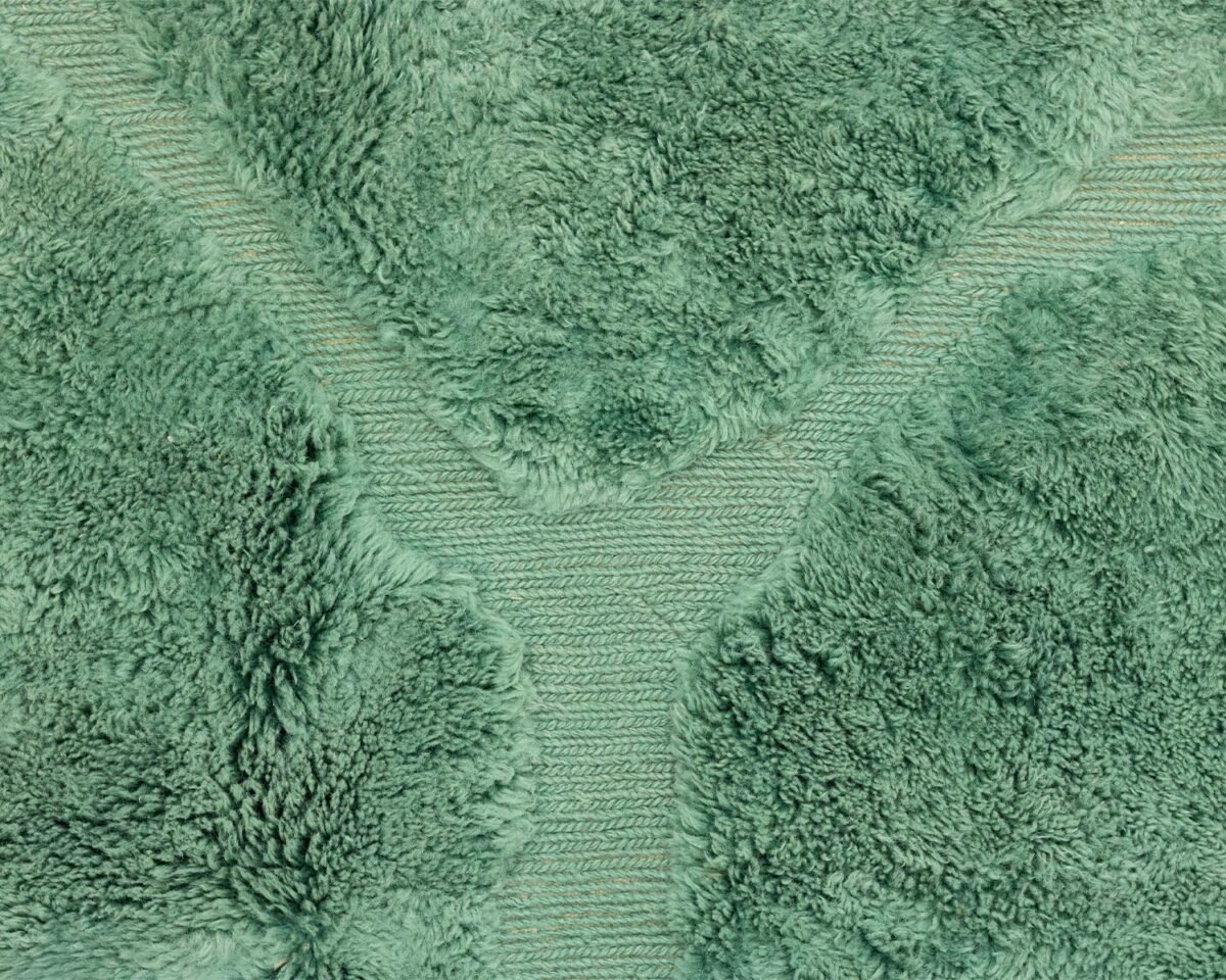 Green Moroccan hand knotted rug featuring a subtle abstract pattern that mimics organic shapes, close-up pattern.