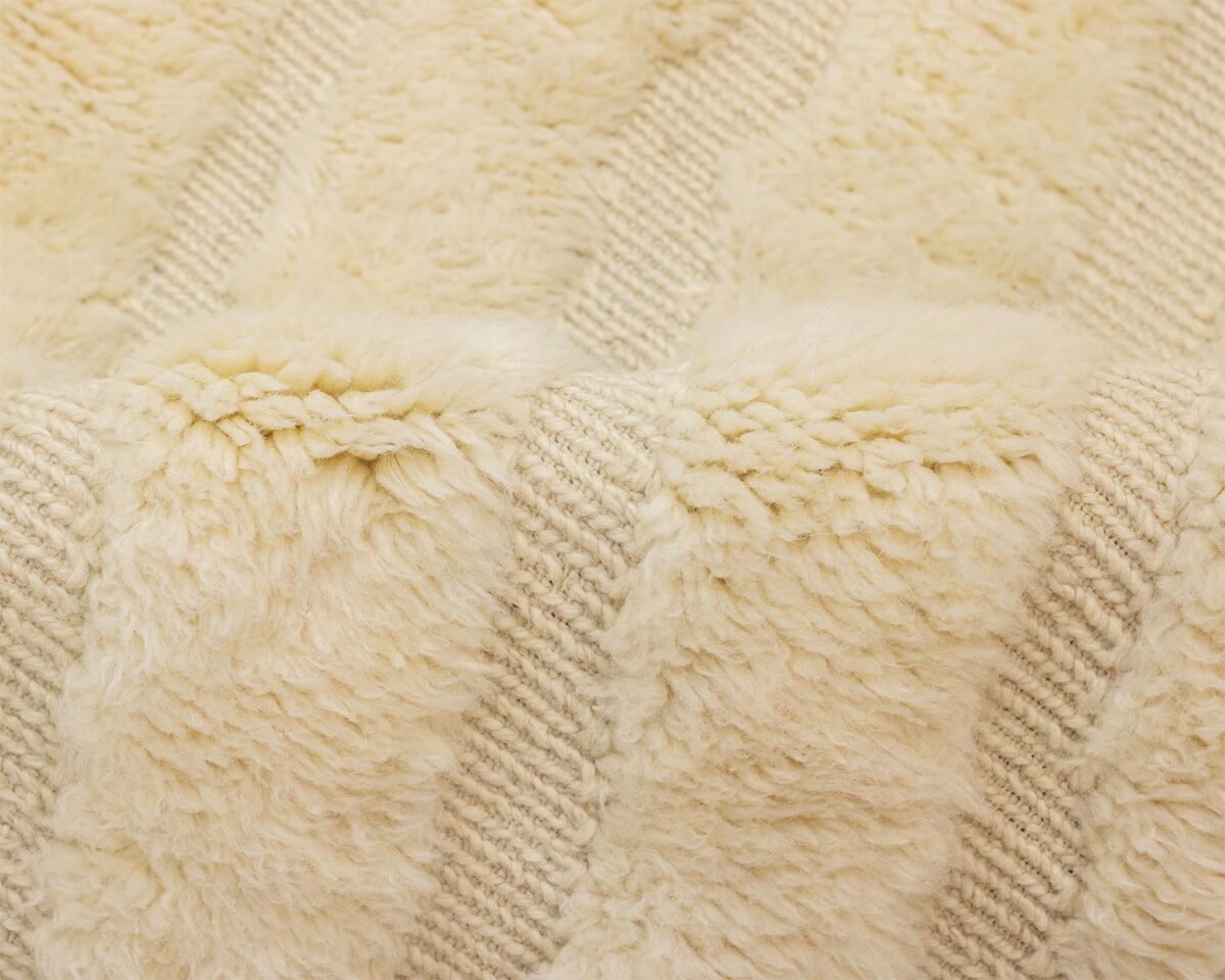 Close-up of a soft, cream-colored textured fabric showcasing an intricate woven design.