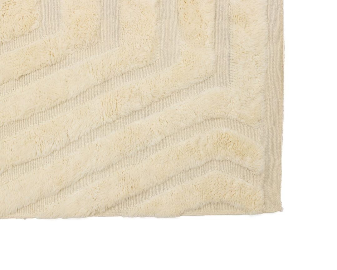 A close-up view reveals a cream-colored textured fabric featuring a classic herringbone pattern.