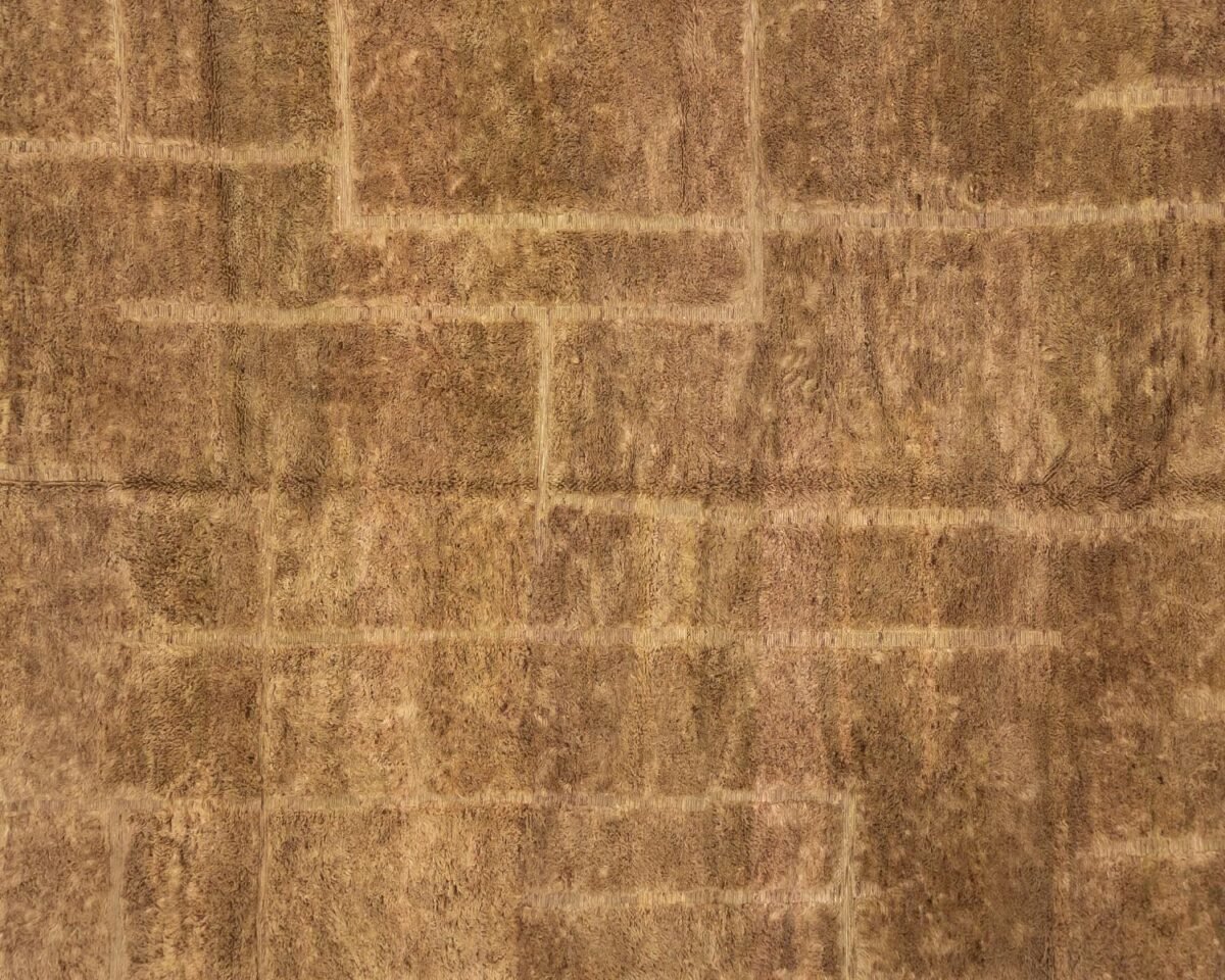 Aerial view of a mosaic of brown, arid fields interwoven by narrow paths.