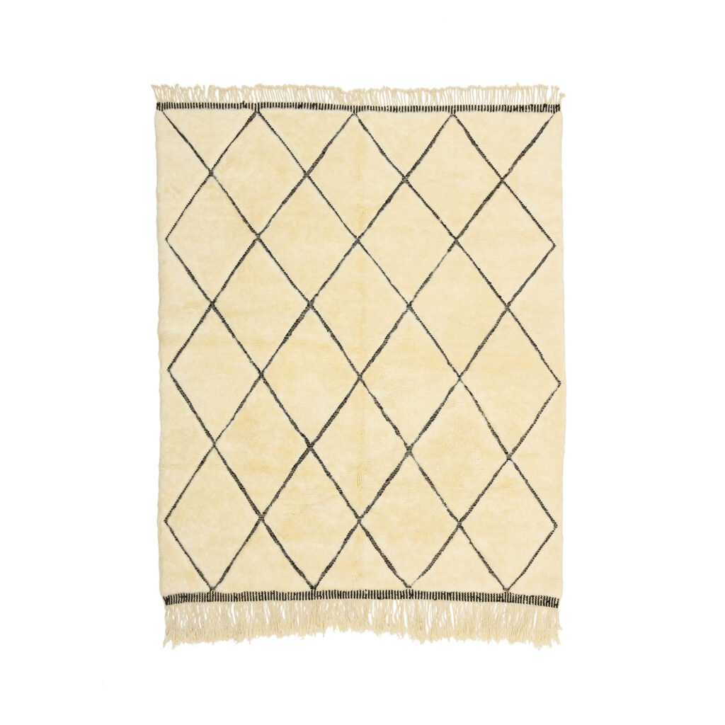 A beige rug adorned with a diamond pattern created by intersecting black lines is a stylish addition to any space. The fringed edges at each end add a touch of elegance and character.