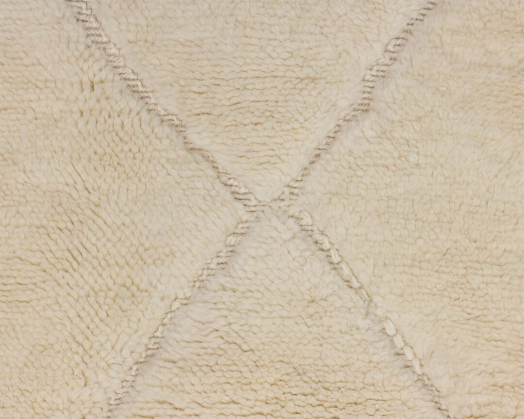 Close-up of a beige, textured rug showcasing a subtle diamond pattern created by intersecting lines, adding elegance to any room.