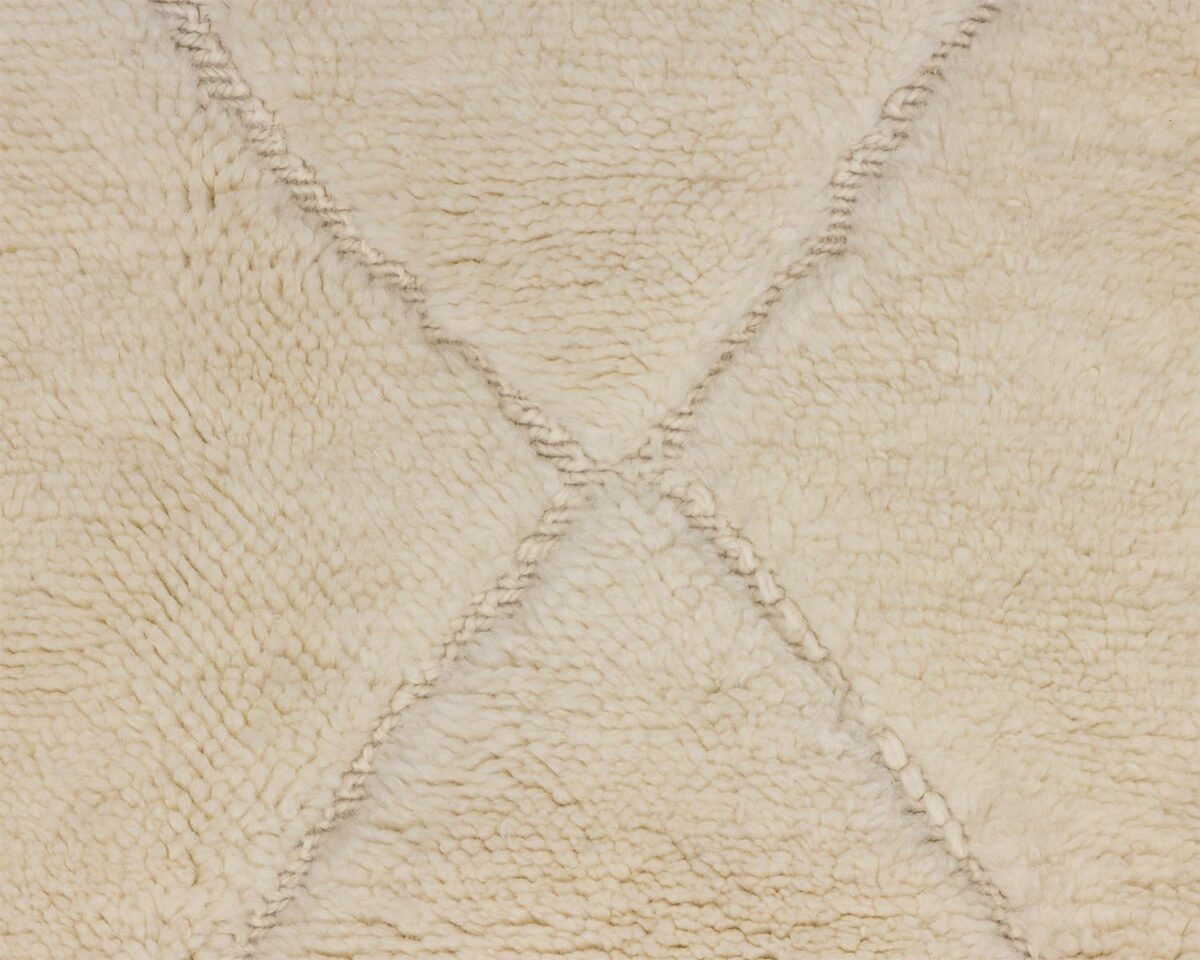 Close-up of a beige, textured rug showcasing a subtle diamond pattern created by intersecting lines, adding elegance to any room.