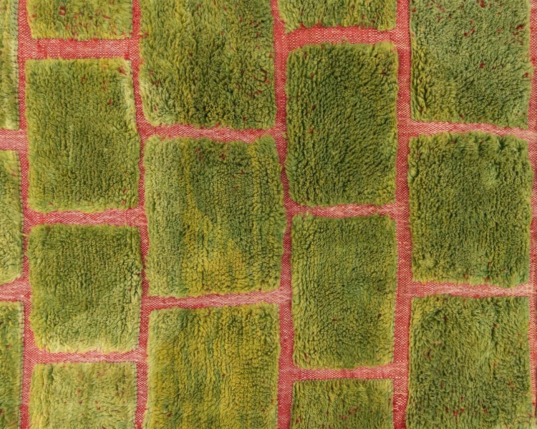 Green Moroccan rug with a textured brick pattern in contrasting red, pattern detail