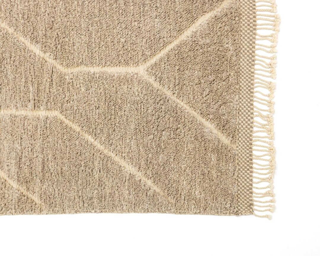 Experience the intricate beauty of a hand-knotted Moroccan rug with its beige textured surface, vibrant geometric pattern, and delicate fringed edge. This luxury rug adds an elegant touch to any space.