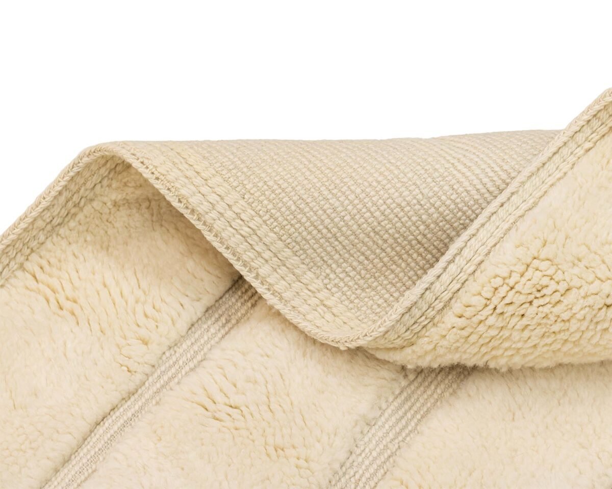 A cozy beige fleece with a soft, fluffy texture and a smooth woven underside, partially folded.