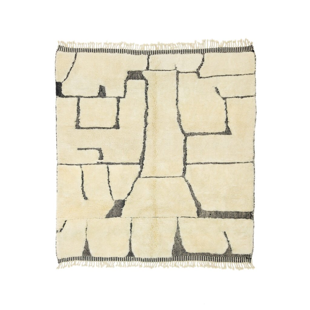 A stylish square beige rug featuring sleek black geometric line patterns. It showcases fringed edges on two sides, enhancing its modern appeal.