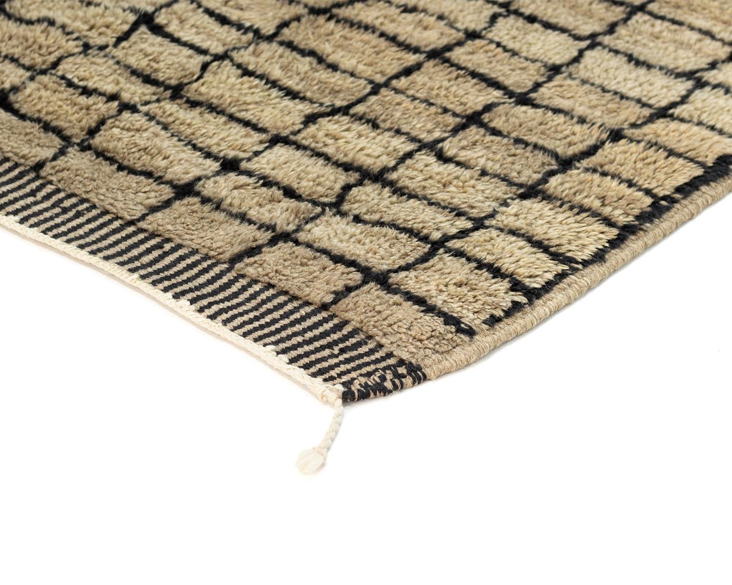 Experience the intricate details of this authentic Moroccan rug, hand-knotted with precision. Its beige surface features a grid pattern, bordered by a striking black striped edge. A unique touch is the loose thread extending from one corner, adding character to its elegant design.