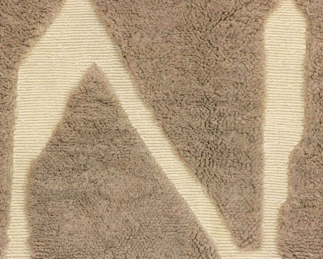 A close-up of a textured luxury rug showcases a raised beige geometric pattern on a cream background, adding an element of sophisticated charm to any space.