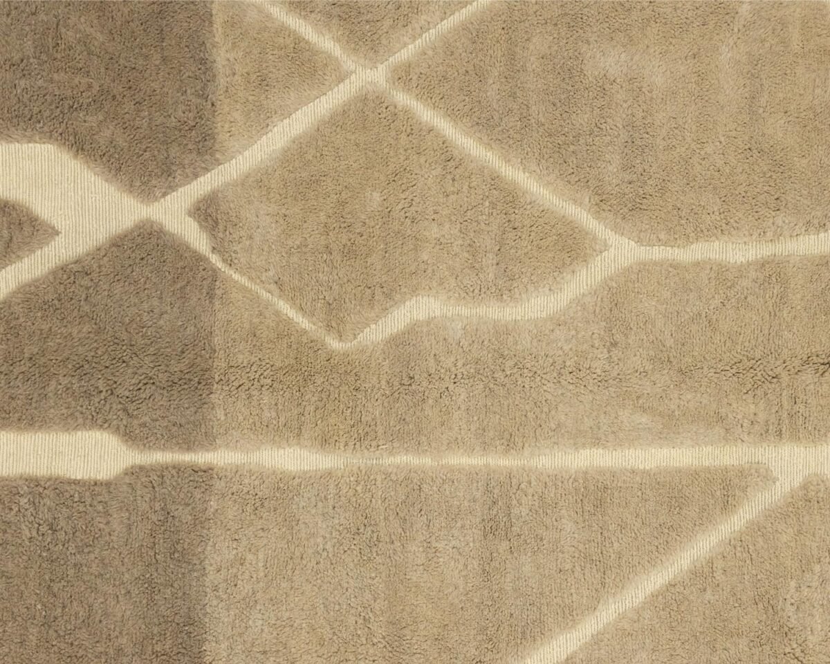 This luxury rug features a close-up view of its hand-knotted geometric pattern, showcasing intersecting lines and shapes in varying shades of beige. Perfect for adding an elegant touch to any room, it embodies the refined craftsmanship of handmade home decor.