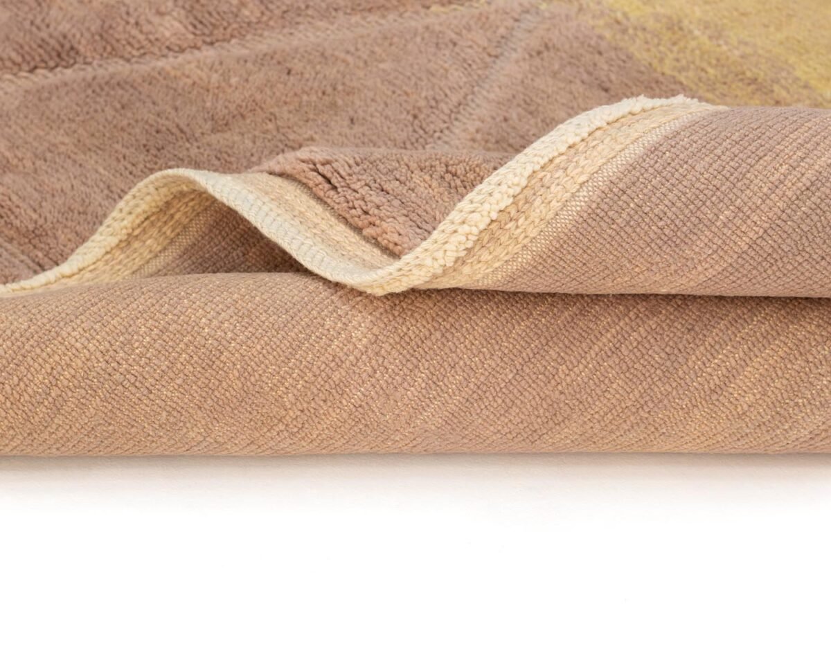 Close-up of a hand-knotted beige and brown textured fabric resembling a Moroccan rug with intricate, layered edges.