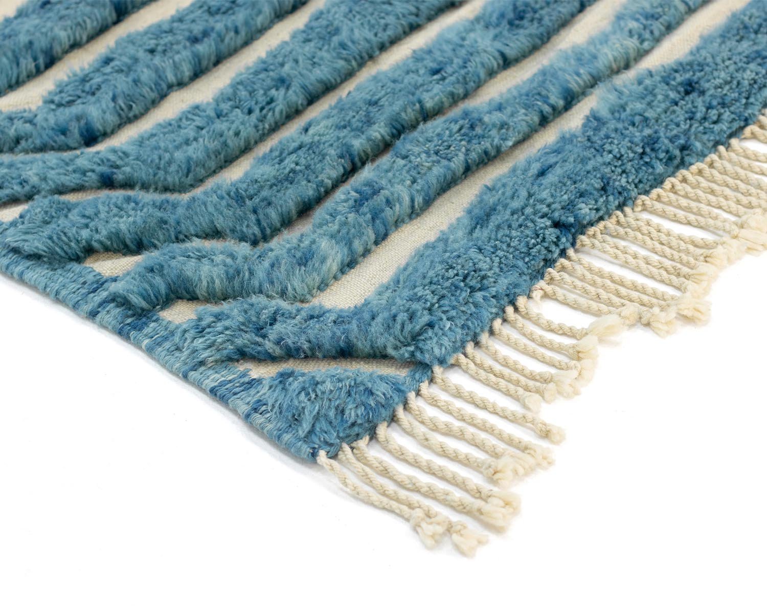 Detailed view of the blue and white handwoven Moroccan rug showing the franges of the rug