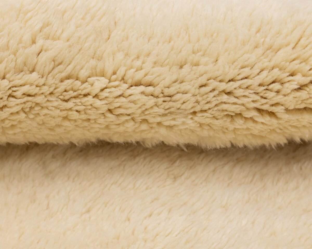 Close-up of beige, fluffy fabric texture, highlighting the soft, woolly surface with dense fibers reminiscent of an authentic Moroccan rug.