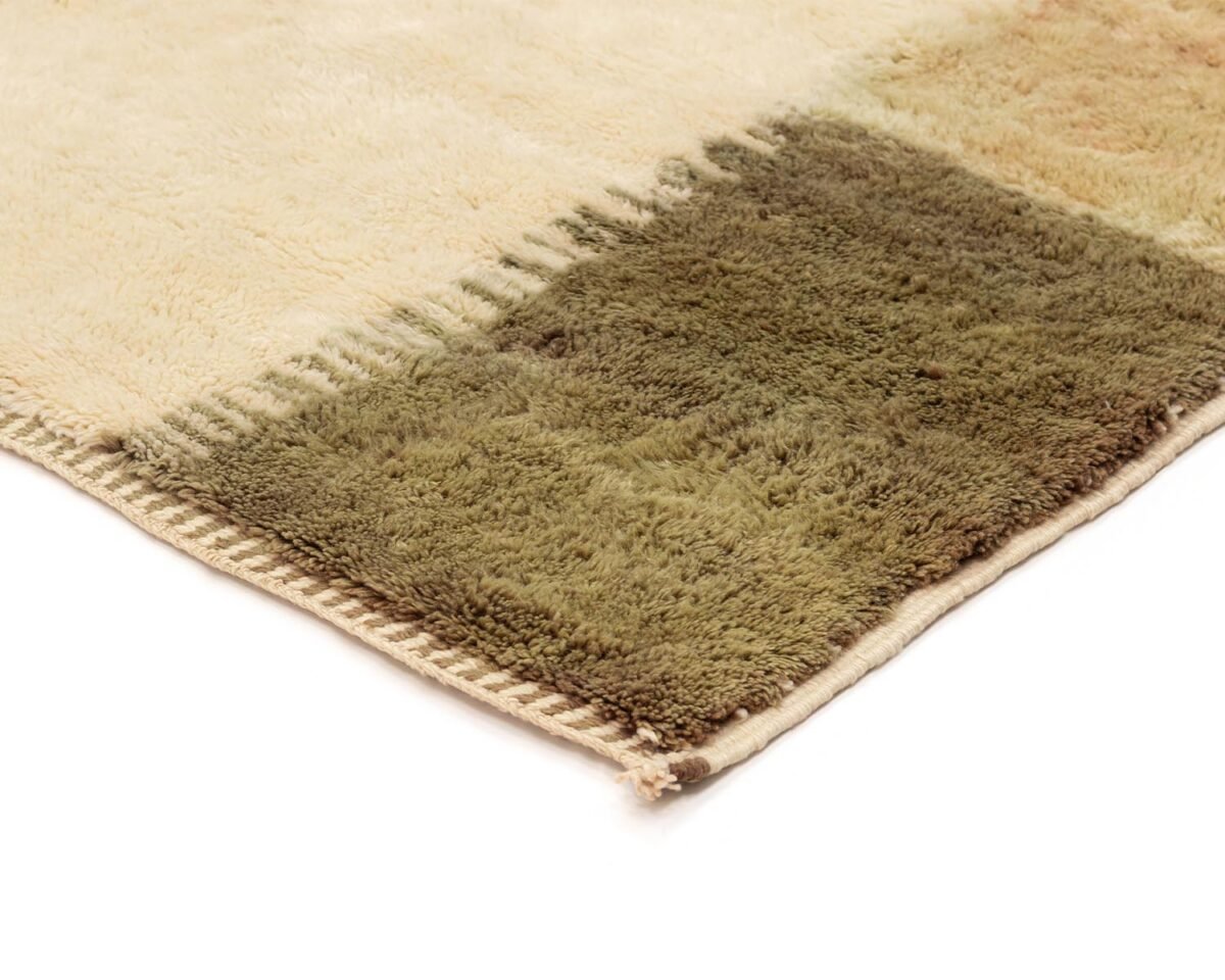 Close-up of a beige and green luxury rug, showcasing the hand-knotted detail with color blocks on the edge, perfect for adding a touch of handmade home decor.