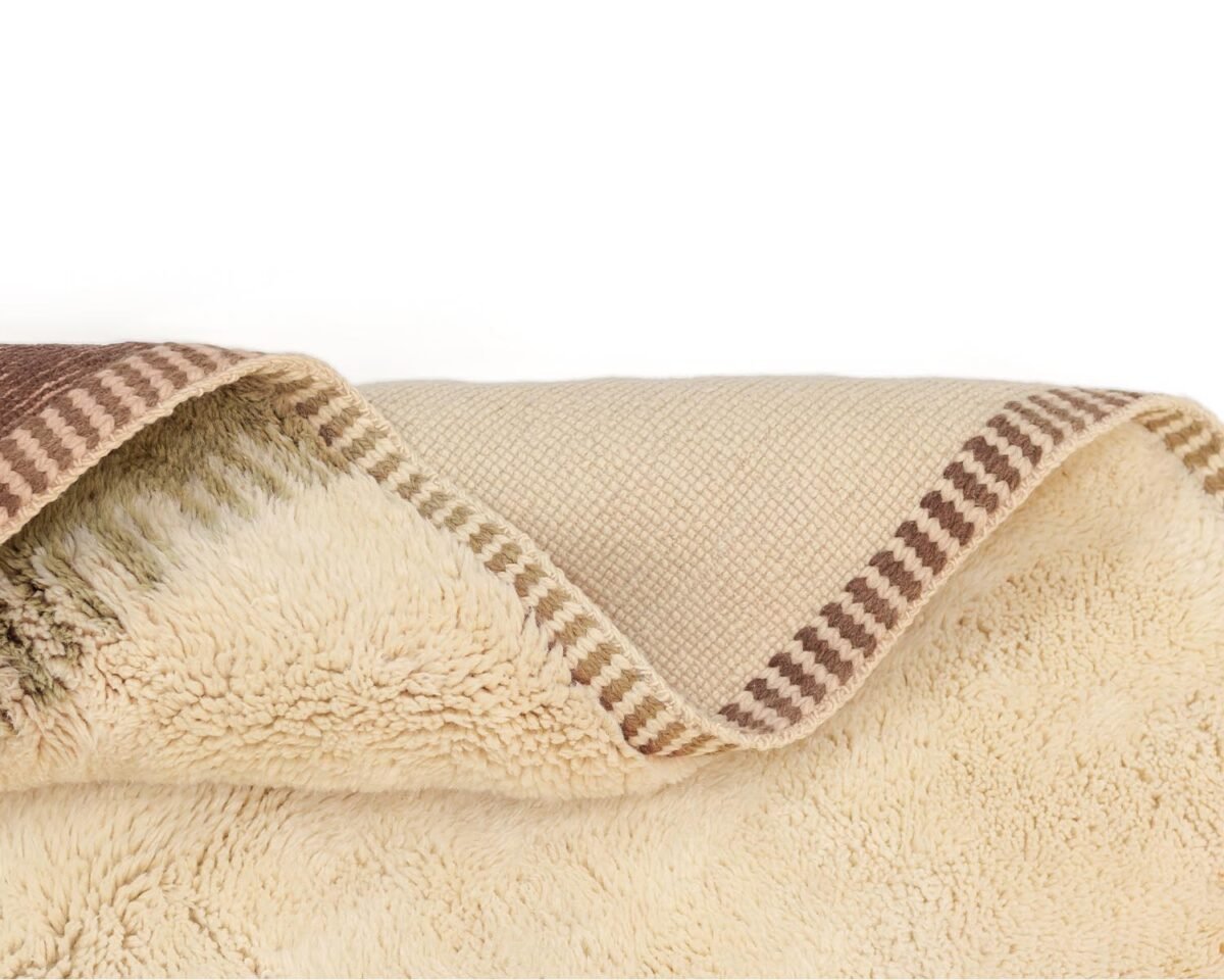 Close-up of a luxurious handmade home decor piece, featuring beige and brown woven patterns with a striped border.