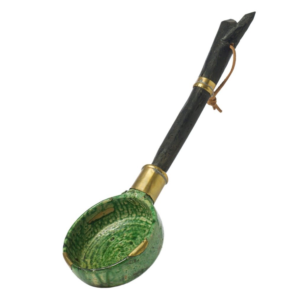 A Tamegroute pottery-inspired green ceramic ladle with a rounded bowl, enhanced by a dark wooden handle featuring brass accents and a leather strap.