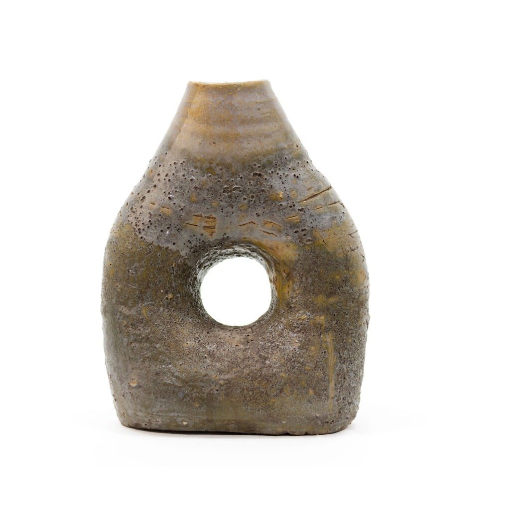 A textured, cone-shaped ceramic vase reminiscent of Tamegroute pottery, with a wide base, earthy tones, and a circular hole in the center of its body.
