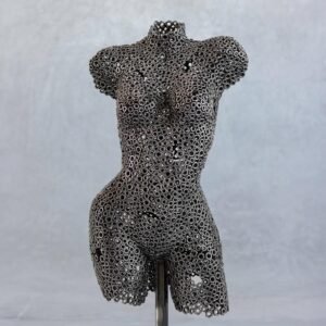 Feminine-shaped metalwork sculpture of a human torso crafted from interconnected metal washers, set against a plain gray background.