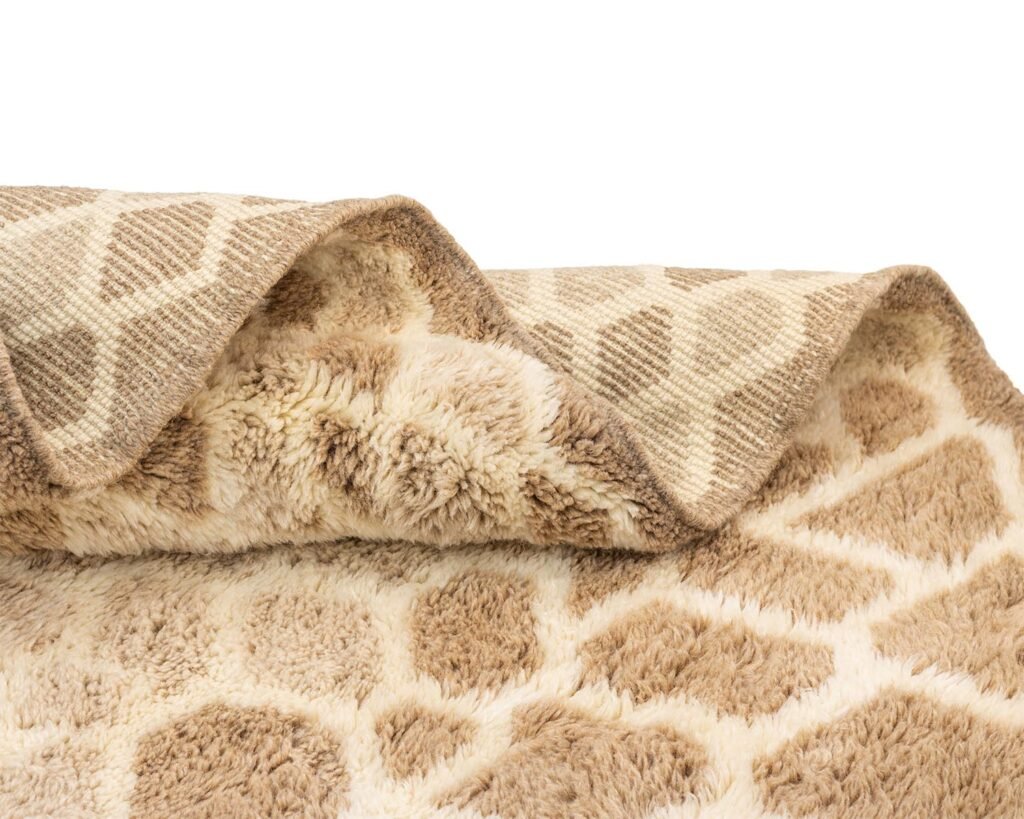 Close-up of a beige and brown artisanal rug with a wavy pattern, highlighting both the soft, fluffy side and the textured, less furry surface.