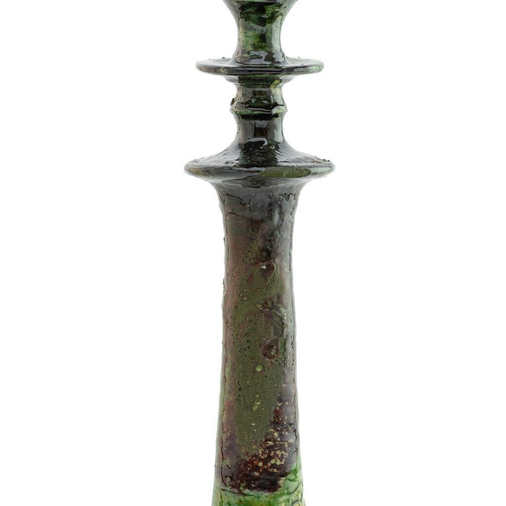 The tall green ceramic vase, inspired by Tamegroute pottery, showcases a textured surface and layered design, featuring a narrow neck and flared top.