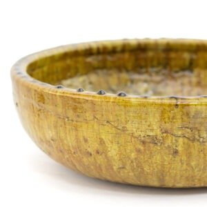 A close-up of a brown ceramic bowl showcases the art of Tamegroute pottery, with its textured surface, glossy finish, and subtle variations in color.