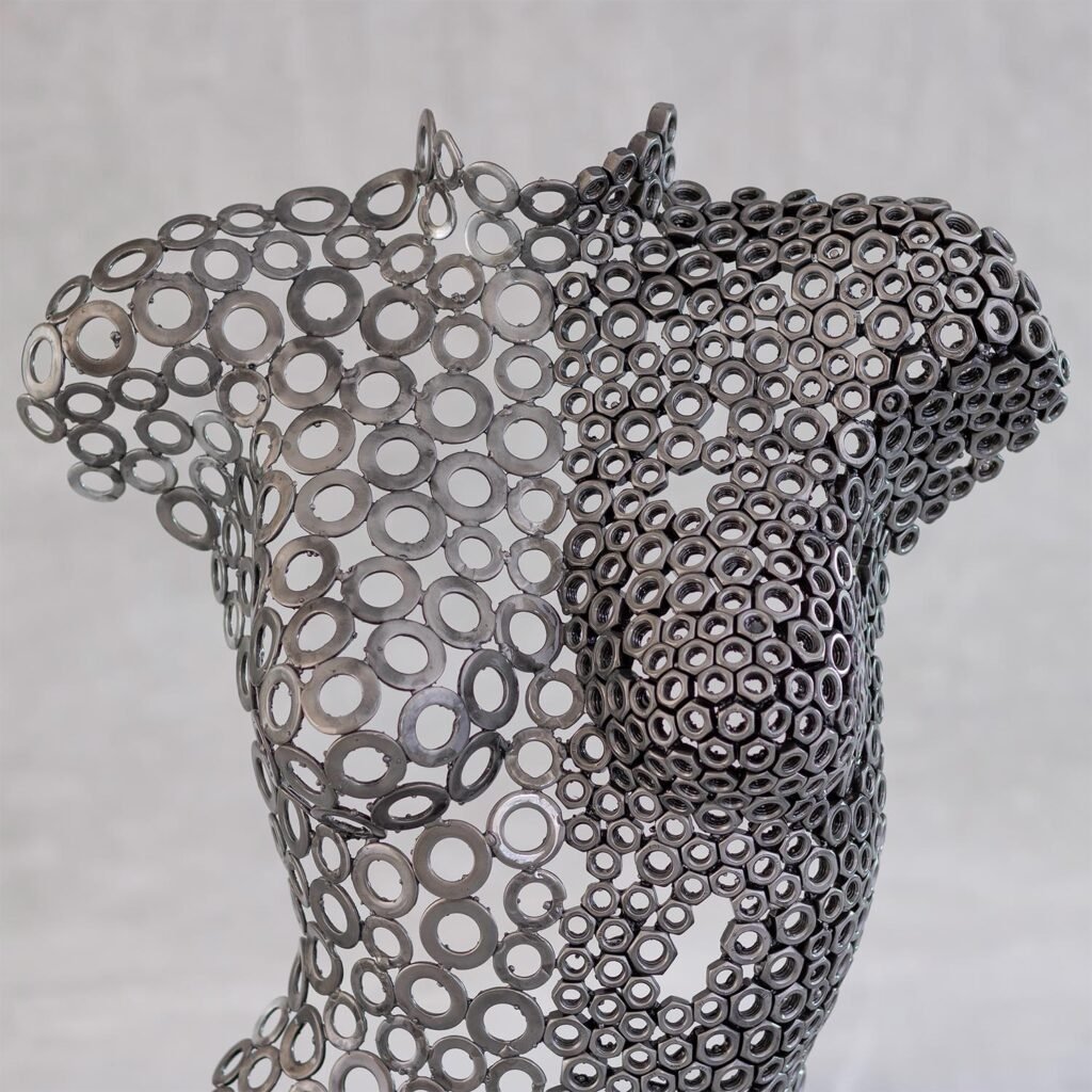A stunning metalwork sculpture of a womans upper body, crafted from interconnected rings, showcases an abstract and intricate design against a neutral background.