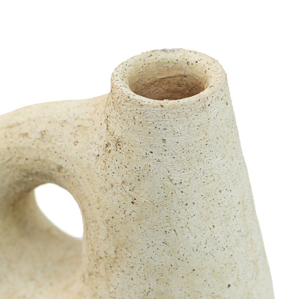 Close-up of a textured, beige ceramic vase with an abstract shape and narrow opening, reminiscent of Tamegroute pottery artistry.