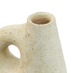 Close-up of a textured, beige ceramic vase with an abstract shape and narrow opening, reminiscent of Tamegroute pottery artistry.