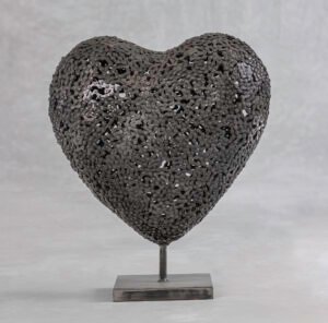 Handmade heart-shaped metal sculpture crafted from interconnected, twisted pieces, beautifully mounted on a square base. Perfect for adding an artistic touch to your home decor.