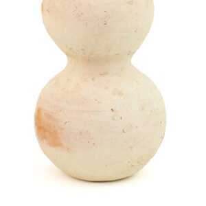 An unglazed, off-white ceramic vase with a double-gourd shape echoes the earthy texture of Tamegroute pottery, set against a soft white background.