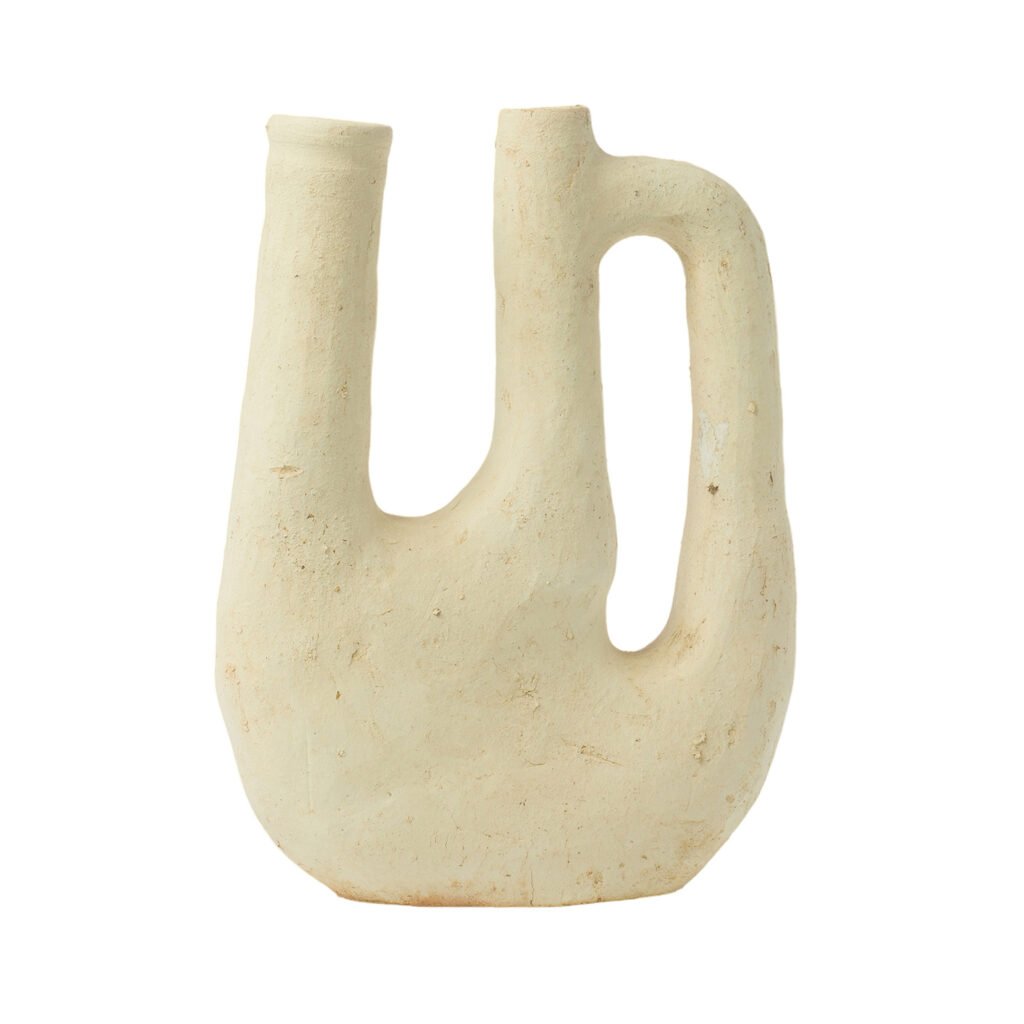 An unglazed, sculptural, pale beige ceramic vase features three elongated spouts and an integrated handle on one side, reminiscent of Tamegroute potterys distinctive style.