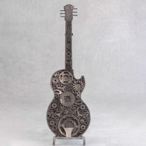 A handmade, guitar-shaped sculpture crafted from interconnected gears and metal parts stands elegantly against a plain background, making it a striking piece of home decor.
