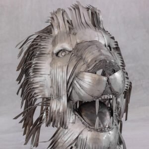 Metal sculpture of a lions head with a mouth open, showing sharp teeth. Made of overlapping strips creating a textured mane against a plain background.