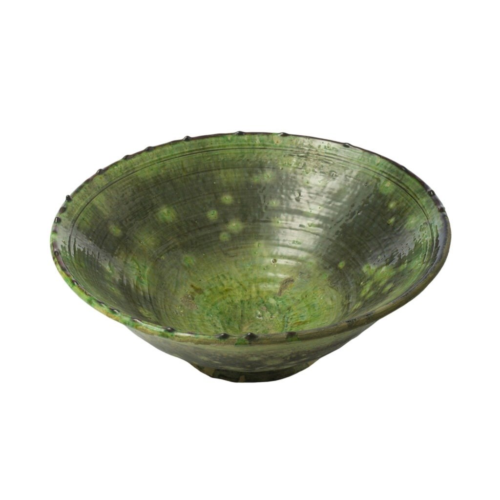 A green ceramic bowl with a textured surface and subtle dark speckles, featuring a slightly outward-flaring rim, reminiscent of Tamegroute potterys unique charm.